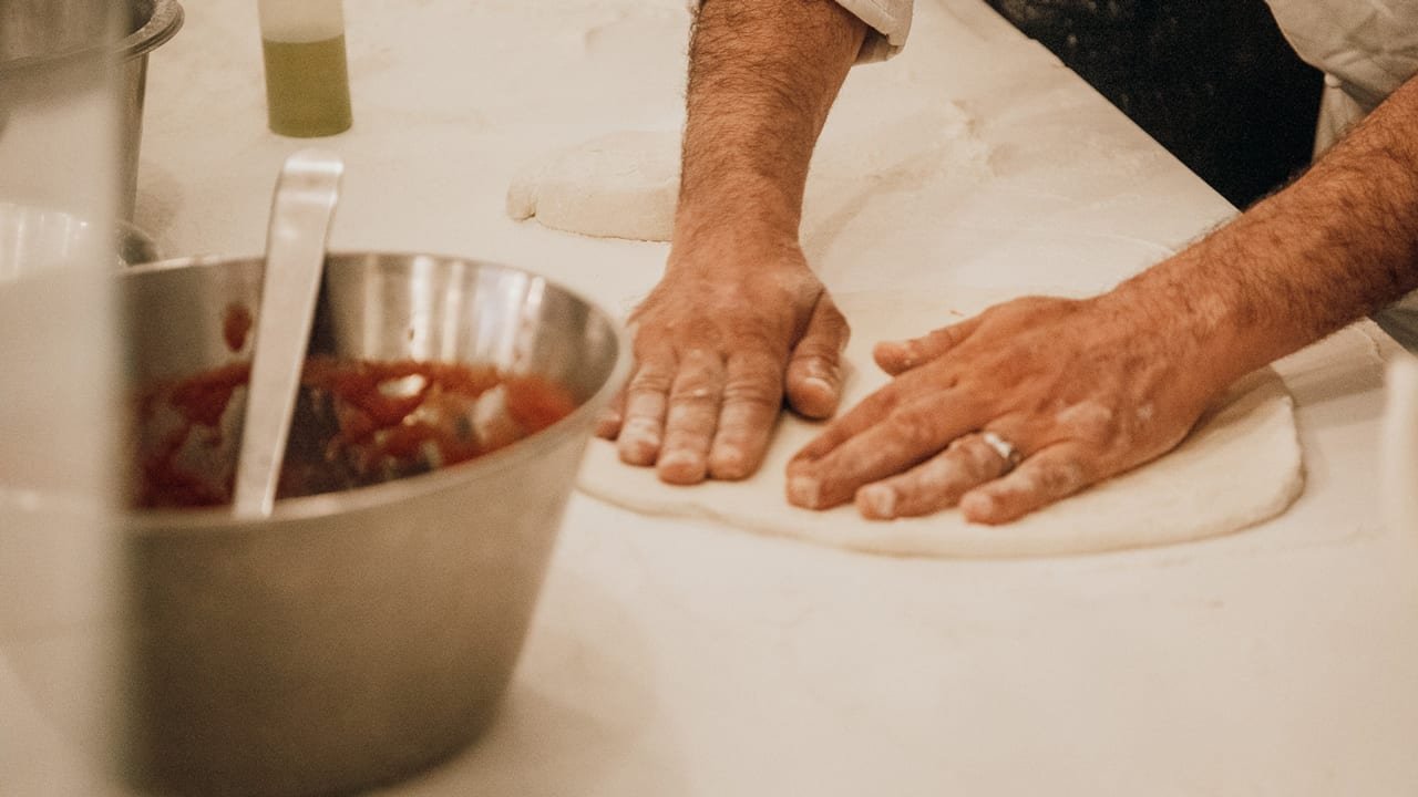 a man showing Italian Pizza cooking tips