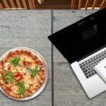 image of pizza and computer and a notebook