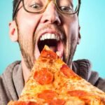 A man eating a slice of pizza
